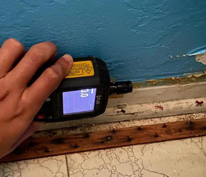 Picture is a moisture detection meter reading a 0 post-remediation.